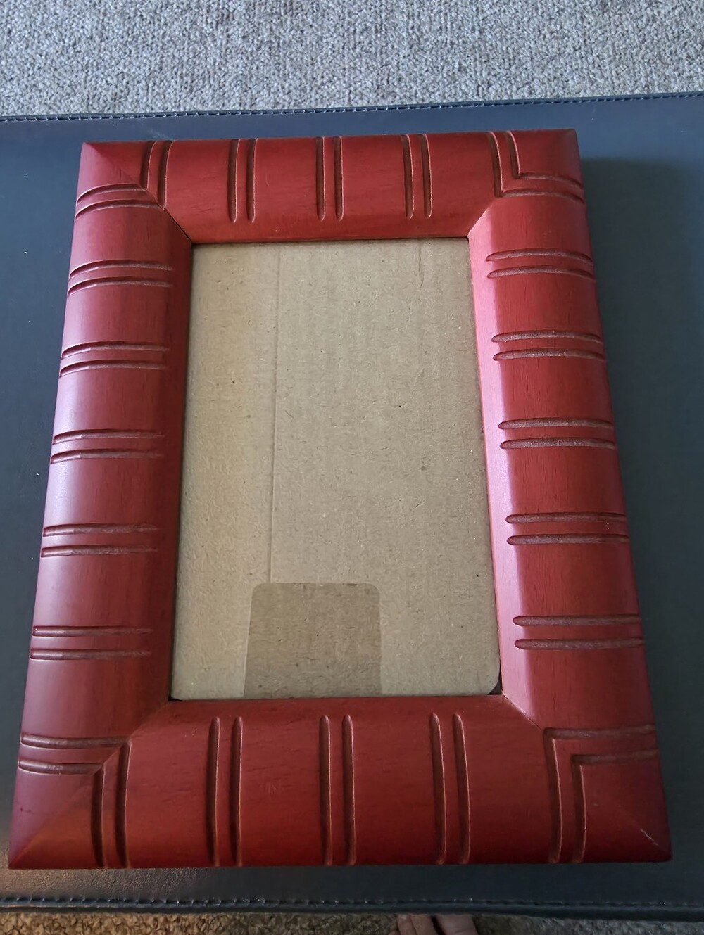 red decorative picture frame with a thick, textured, and ridged border design.